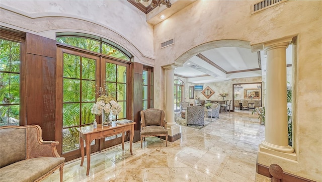 interior space featuring decorative columns, arched walkways, visible vents, and french doors