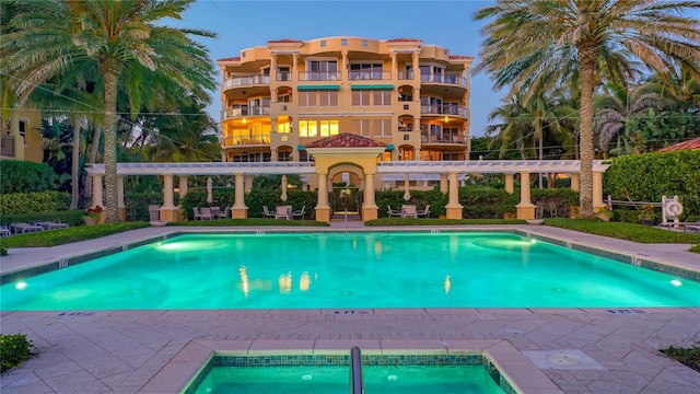 community pool with a pergola and a patio