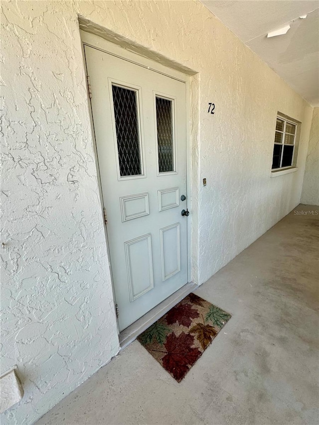 doorway to property with stucco siding