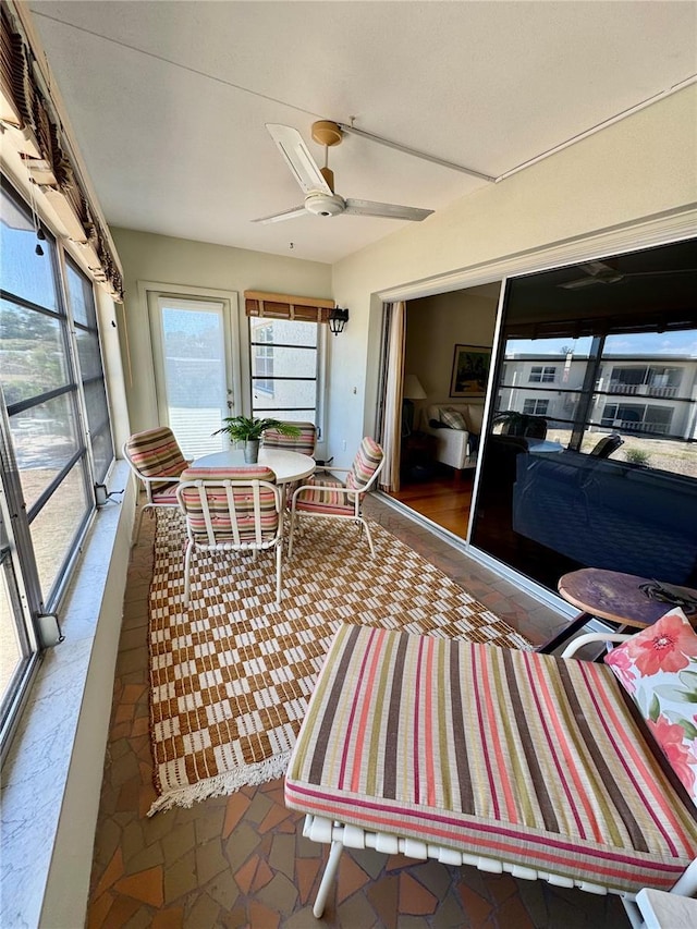 sunroom / solarium featuring a ceiling fan