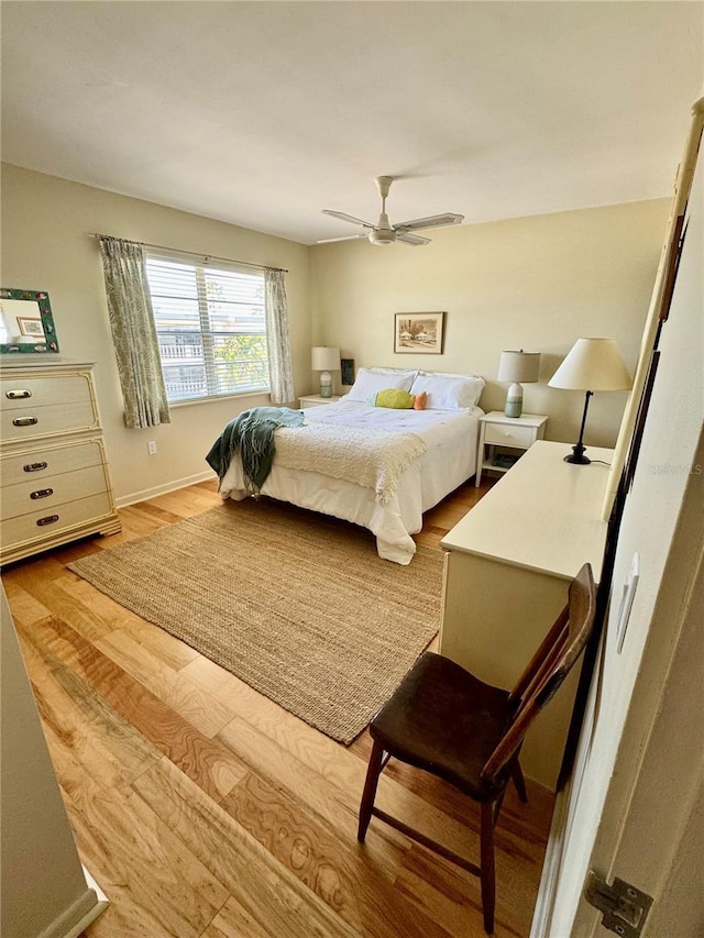 bedroom with wood finished floors, baseboards, and ceiling fan