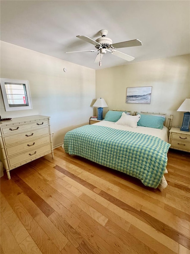 bedroom with wood finished floors, baseboards, and ceiling fan