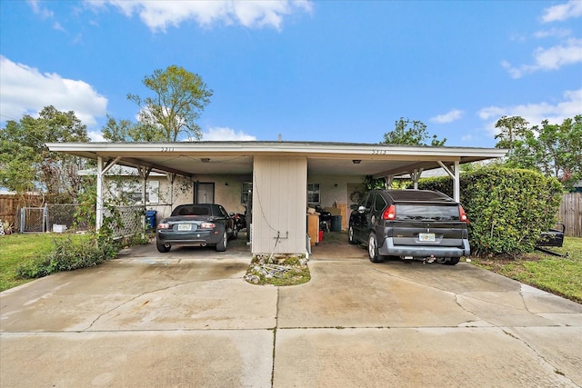 view of parking / parking lot featuring an attached carport and driveway