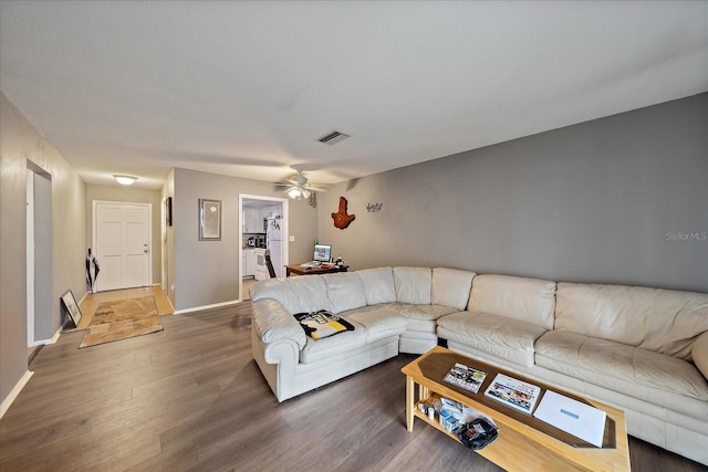 living area with visible vents, wood finished floors, baseboards, and ceiling fan