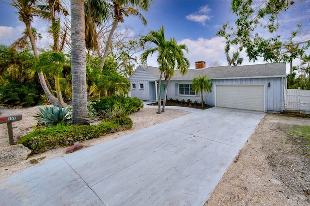 552 Juan Anasco Dr, Longboat Key, FL 34228 - single story home with concrete driveway, an attached garage, a chimney, and board and batten siding