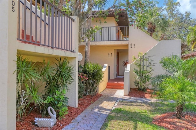 view of front of home with a balcony and stucco siding