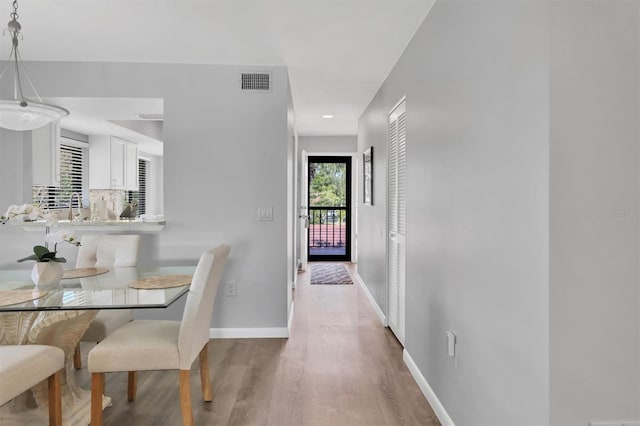 dining space with baseboards, visible vents, and wood finished floors