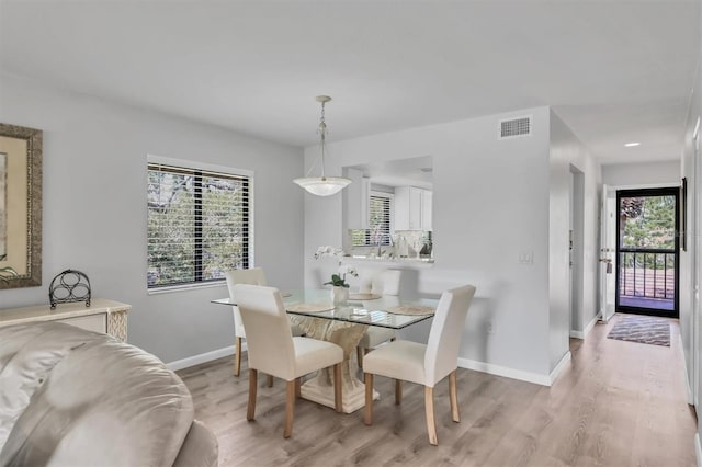 dining room with light wood-style floors, baseboards, and visible vents