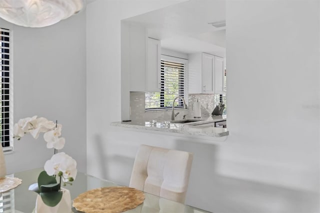 interior details featuring tasteful backsplash, a sink, and visible vents