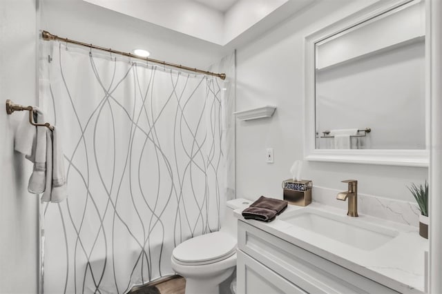 bathroom featuring curtained shower, vanity, and toilet