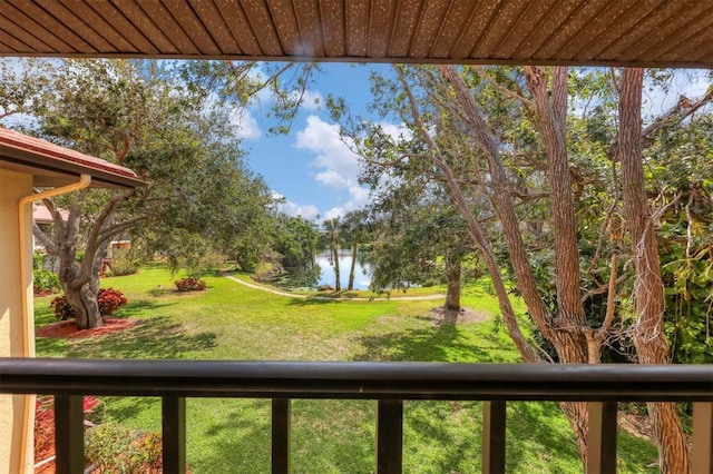 view of yard with a water view and a balcony