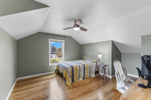 bedroom featuring lofted ceiling, wood finished floors, and baseboards