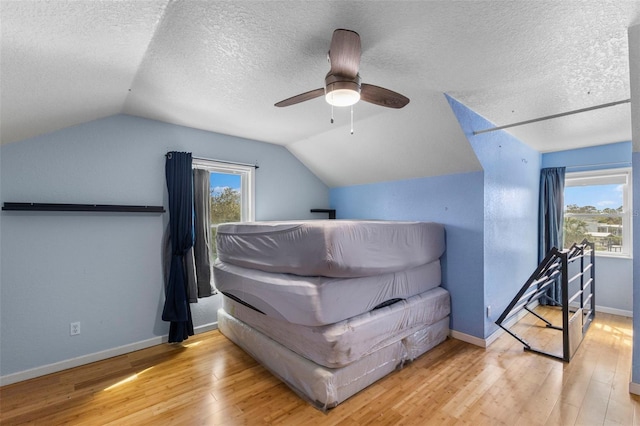 bonus room with lofted ceiling, a textured ceiling, baseboards, and hardwood / wood-style floors