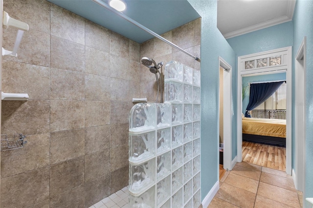 ensuite bathroom featuring baseboards, ornamental molding, tile patterned floors, ensuite bathroom, and a walk in shower