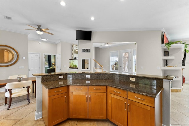 kitchen featuring dark stone countertops, visible vents, and crown molding