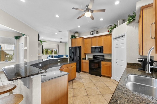 kitchen featuring crown molding, a large island, a breakfast bar area, a sink, and black appliances