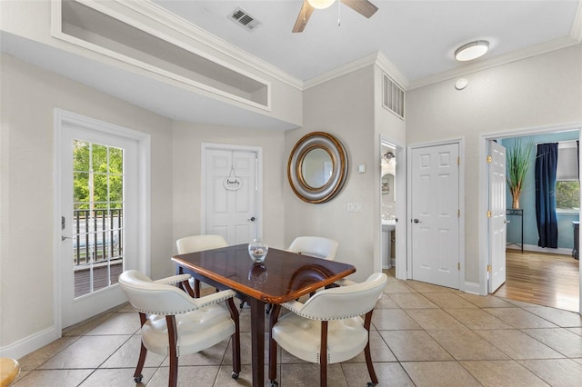 dining space featuring light tile patterned floors, ornamental molding, plenty of natural light, and visible vents