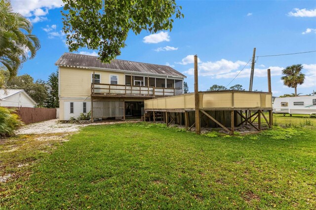 back of property featuring metal roof, a yard, and fence