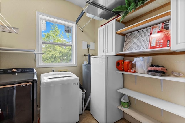 clothes washing area with washing machine and dryer and cabinet space