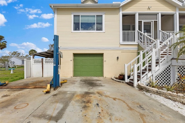 view of front of house featuring a garage, driveway, stairs, a gate, and stucco siding