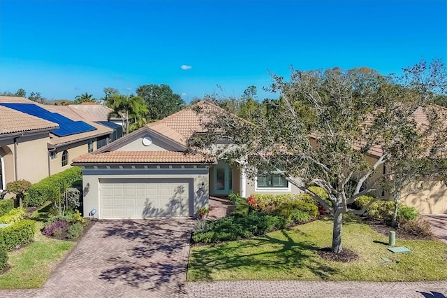 view of front of property with stucco siding, a tile roof, an attached garage, decorative driveway, and a front yard