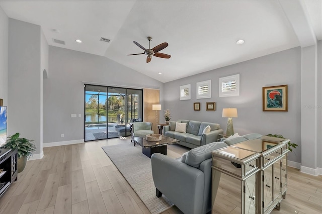 living area featuring light wood-style floors, arched walkways, visible vents, and lofted ceiling