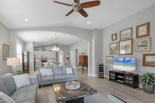 living room featuring arched walkways, recessed lighting, baseboards, vaulted ceiling, and light wood-type flooring