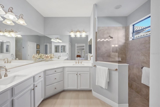 bathroom with double vanity, a sink, and walk in shower