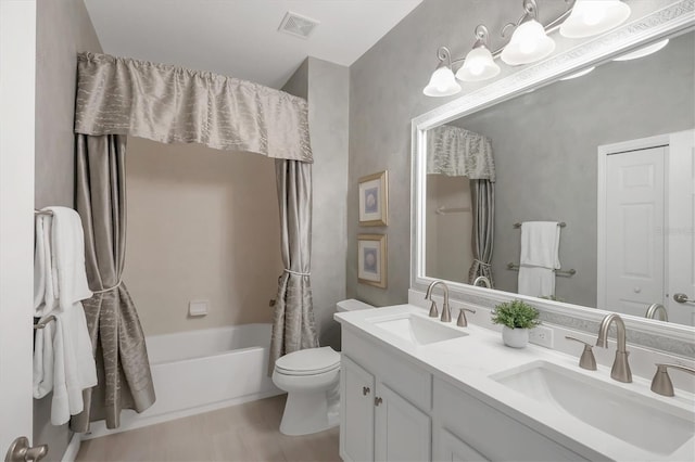 full bathroom featuring toilet, double vanity, a sink, and visible vents