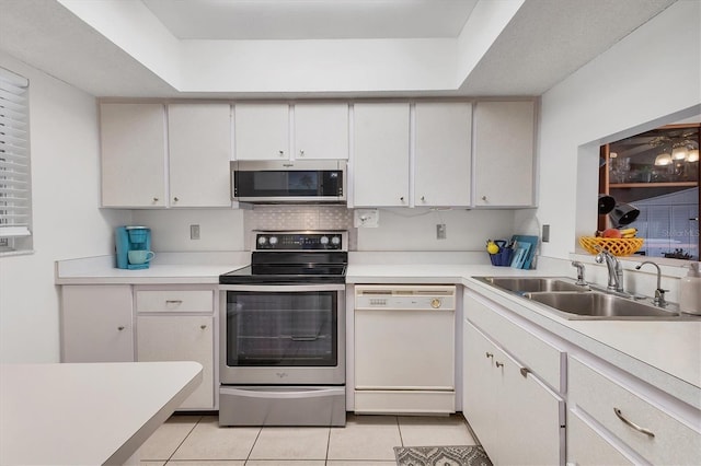 2446 Clubhouse Cir Unit 202, Sarasota, FL 34232 - kitchen with stainless steel appliances, light tile patterned flooring, light countertops, and a tray ceiling