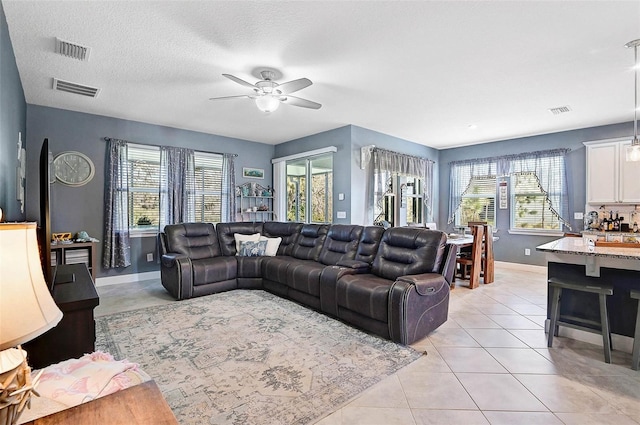 living room featuring visible vents, plenty of natural light, and light tile patterned floors