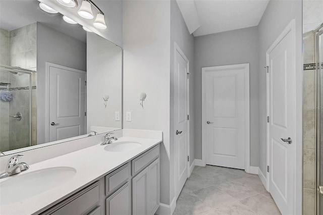 bathroom with a sink, a shower stall, baseboards, and double vanity