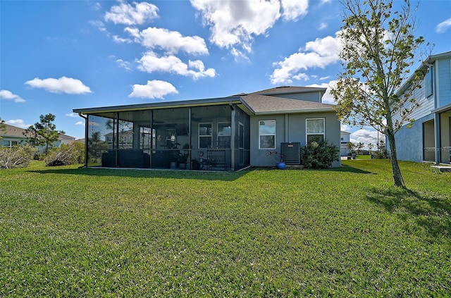 rear view of property with a sunroom, a lawn, and central AC unit