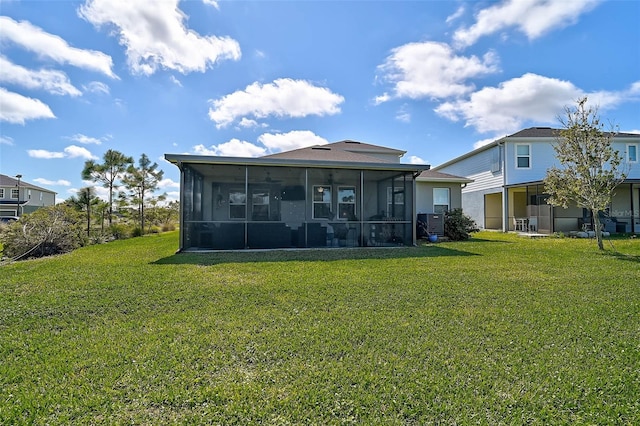 rear view of property featuring a sunroom and a yard