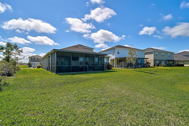 rear view of property with a sunroom and a yard