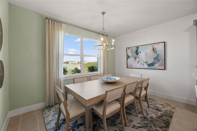 dining room with baseboards, a notable chandelier, and light tile patterned flooring