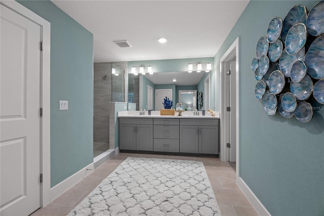 bathroom featuring double vanity, visible vents, tile patterned floors, walk in shower, and a sink