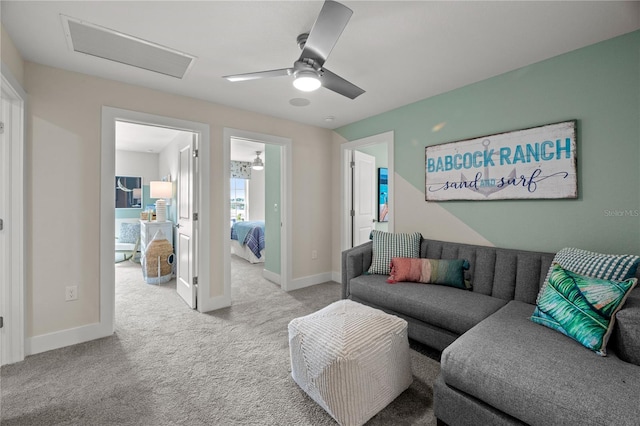 carpeted living area with baseboards, visible vents, ceiling fan, and attic access