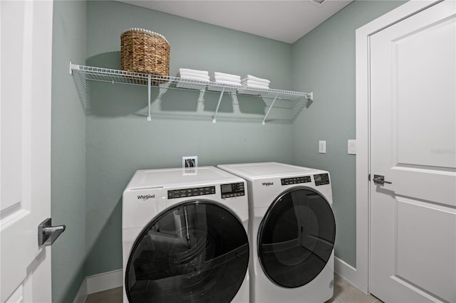 washroom with baseboards, laundry area, and washer and dryer