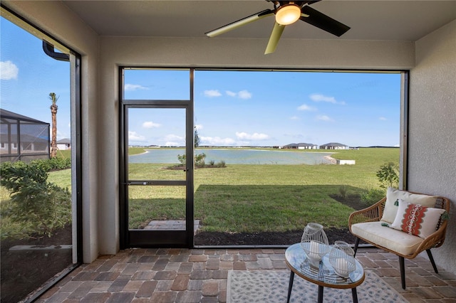 sunroom with a water view and a ceiling fan