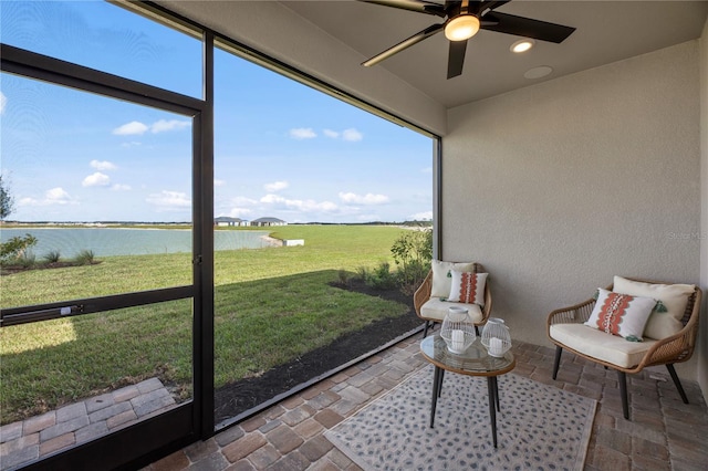 sunroom with a water view and a ceiling fan