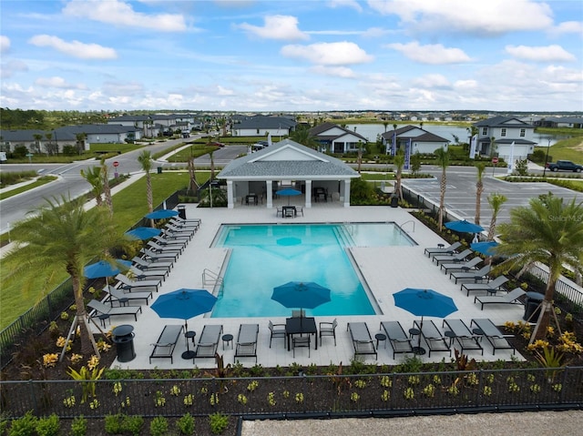 pool featuring a patio area, fence, and a residential view