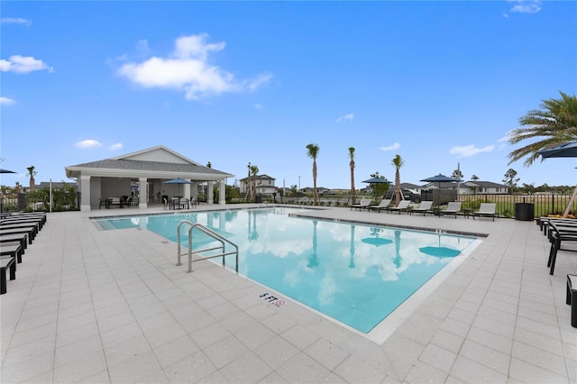 community pool with fence and a patio