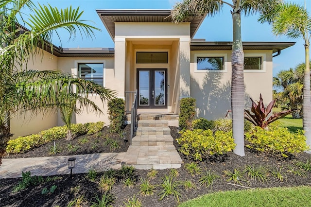 doorway to property featuring stucco siding and french doors