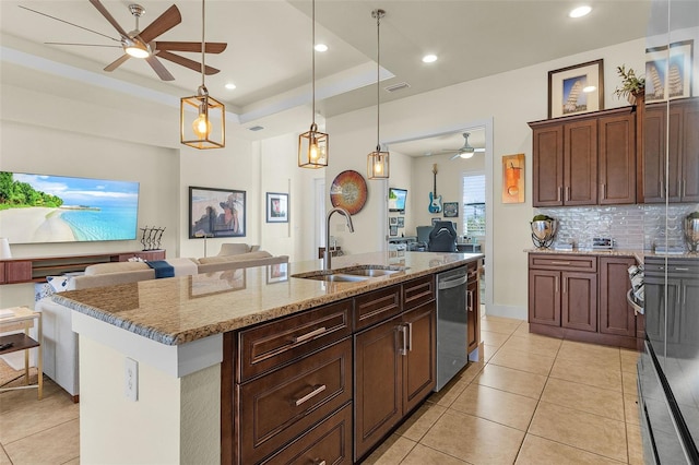 kitchen with a sink, open floor plan, stainless steel dishwasher, decorative backsplash, and a raised ceiling