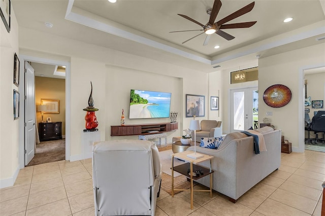 living area with light tile patterned floors, recessed lighting, a raised ceiling, a ceiling fan, and baseboards