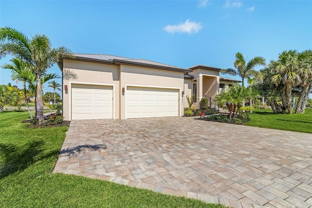 view of front of home featuring an attached garage, a front yard, decorative driveway, and stucco siding