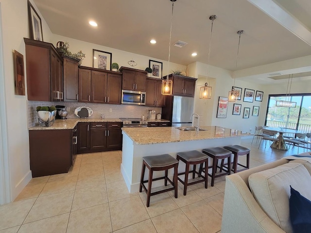 kitchen with stainless steel appliances, tasteful backsplash, and dark brown cabinetry