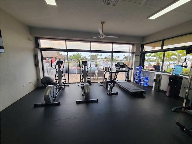 exercise room with a textured ceiling and ceiling fan