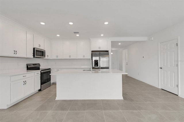 kitchen featuring recessed lighting, white cabinetry, light countertops, appliances with stainless steel finishes, and an island with sink